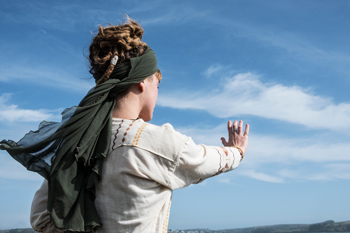 person in historical attire gesturing towards the sky with a scenic background representing 10 ways to engage with nature