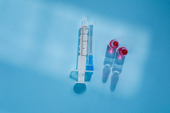 syringe and two test tubes with red caps on a blue surface representing medical analysis and healthcare tools 4 essential items for tests